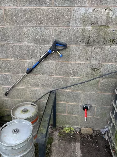 Outdoor connection point and pressure washer trigger gun installed for external cleaning at a Twycross farm.